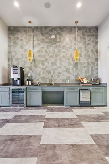 A kitchen with a checkered floor and a green backsplash.